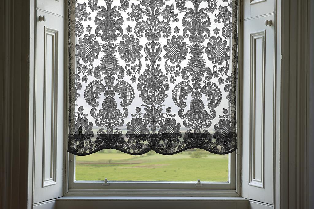 Ivory custom roller shade featuring a detailed Scottish Madras damask pattern with a scalloped bottom edge.