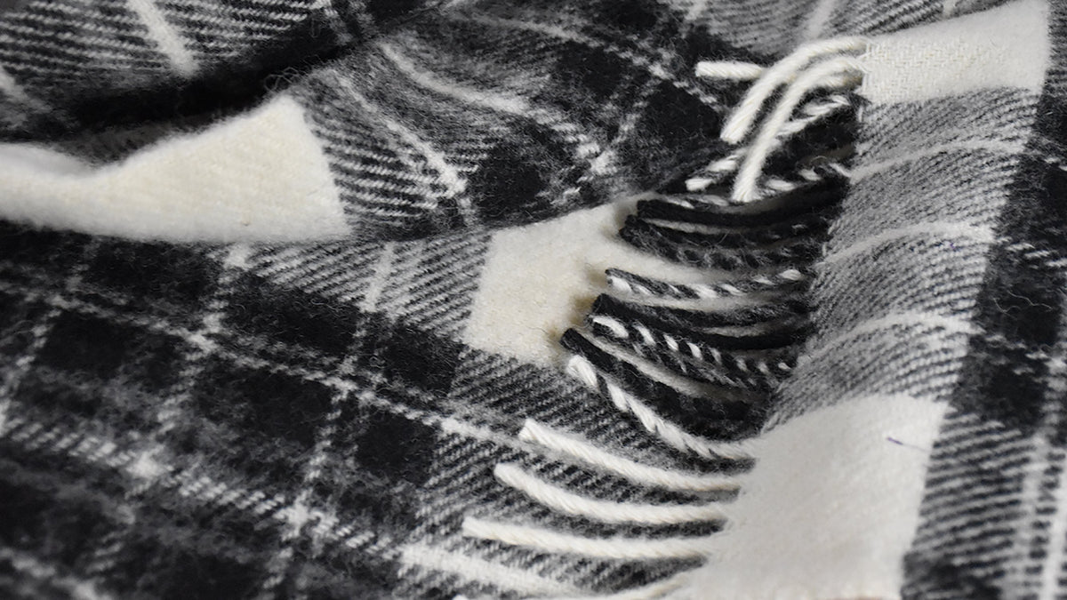 Grey Dress Stewart tartan throw in pure new wool with a thick, fluffy texture and decorative fringe detail.