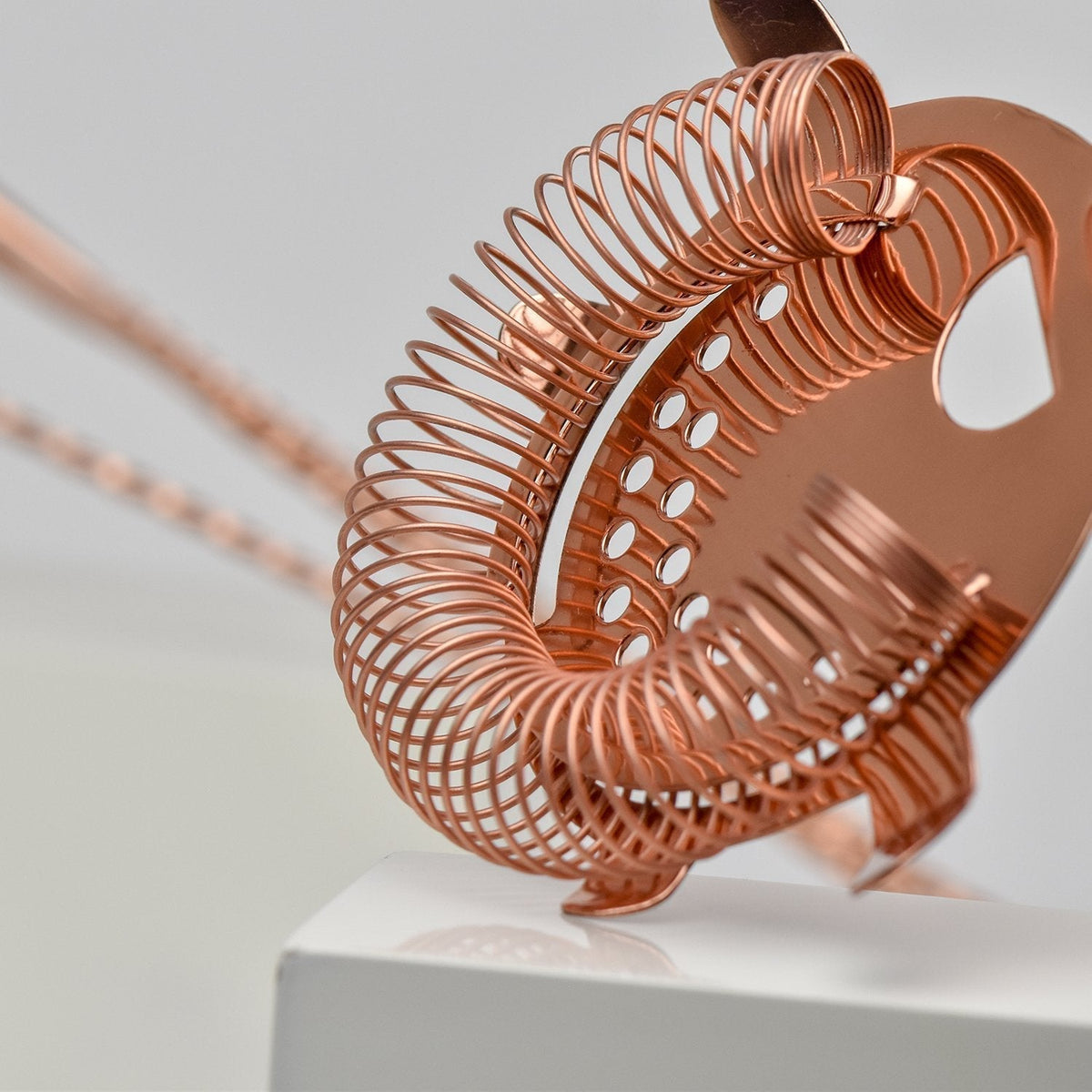 Copper 4-prong bar strainer with a coiled wire spring, designed for Boston cocktail shakers.
