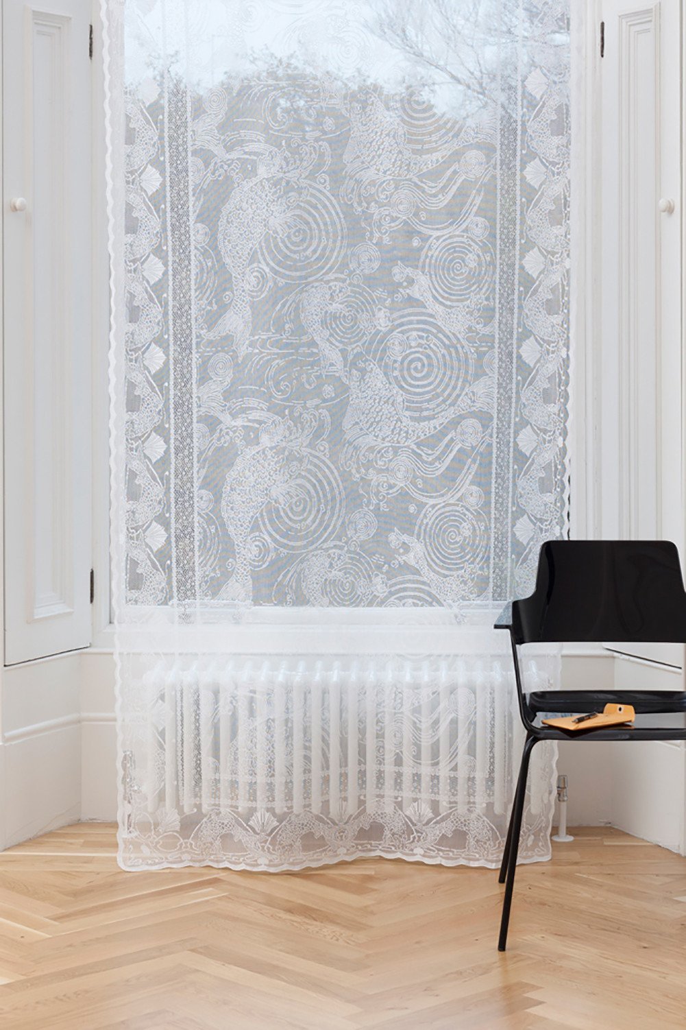 White Scottish lace window panel featuring an intricate Japanese carp and swirl pattern, woven in a cotton-poly blend.